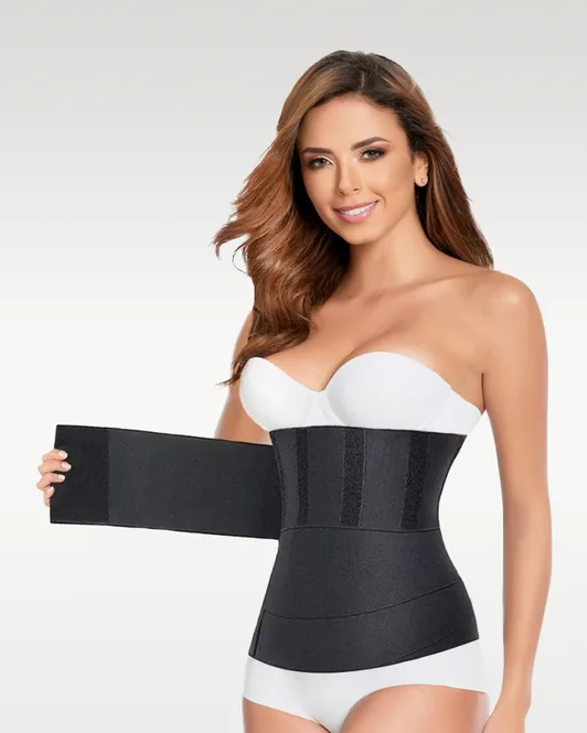 Bandage post-partum noir porté à la taille, sa bande velcro en train d’être enroulée
