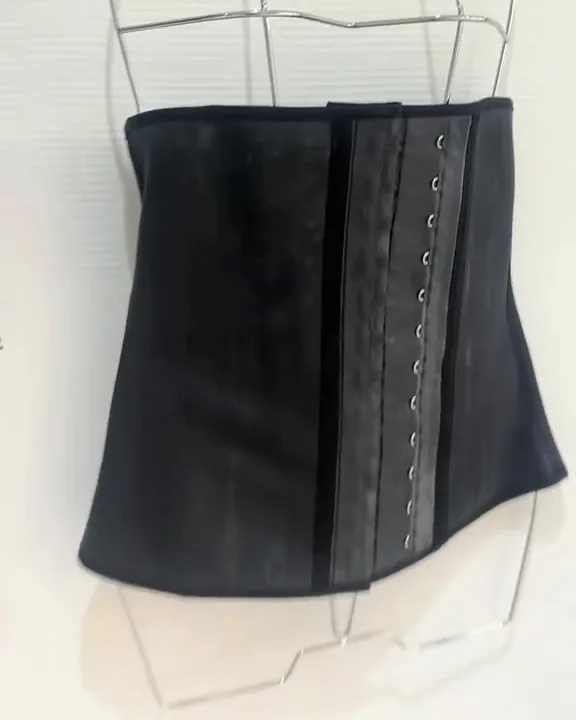 Une gaine latex à crochets sur un buste, à la boutique