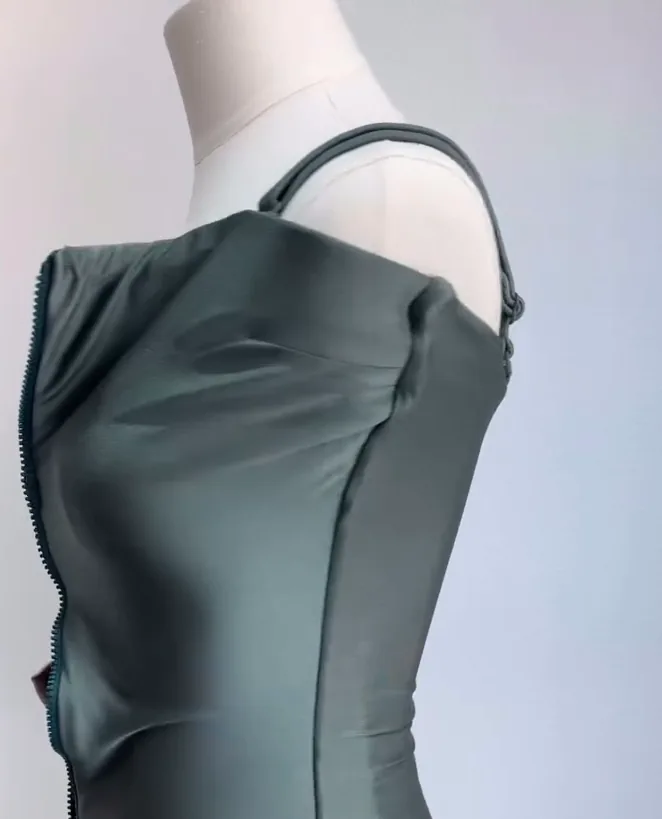 Le maillot de bain gainant vert sur un buste, à la boutique